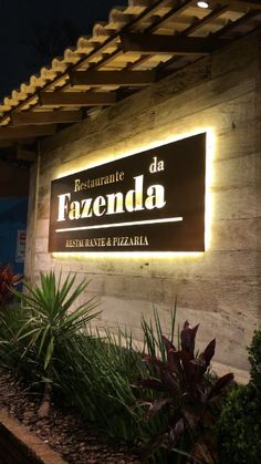 the sign for fazenda restaurant and pizzaria lit up in front of it