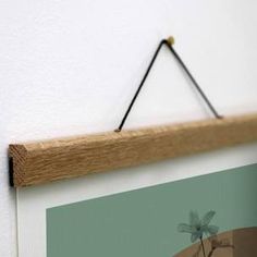 a wooden frame hanging on the wall with a small dragonfly sitting on top of it