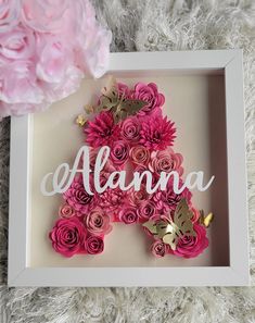 a white frame with pink flowers in it and the word atlanta spelled out on top