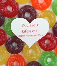 a heart shaped sign surrounded by many colorful donuts