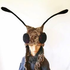 a mannequin wearing a hat and scarf with large black horns on it's head