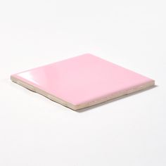 a pink piece of paper sitting on top of a white surface