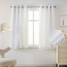 a white chair sitting in front of a window next to a dresser with drawers on it