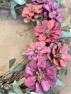 some pink flowers and green leaves on the ground