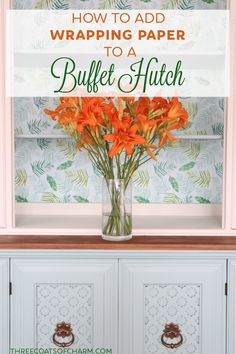 a vase filled with orange flowers sitting on top of a dresser