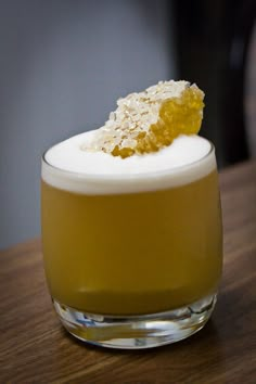 a glass filled with liquid sitting on top of a wooden table