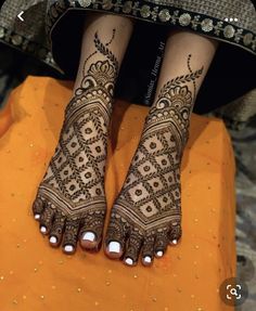 the legs and feet of a woman with henna tattoos