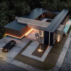 an aerial view of a modern house in the middle of a wooded area at night