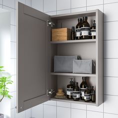 an open medicine cabinet next to a potted plant