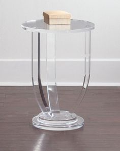 a glass table with a piece of cake on it's top and a white wall in the background