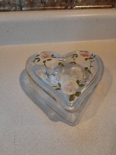 a heart shaped glass box sitting on top of a counter