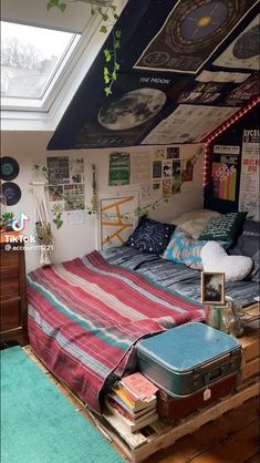 a room with a bed, suitcases and pictures on the wall above it that are covered in posters