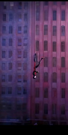 a person hanging upside down on a rope in front of a building with lots of windows