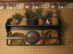 an old fashioned shelf with pots and pans on it