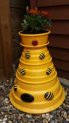 a yellow flower pot with ladybugs painted on it