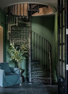 a living room with a spiral staircase next to a blue couch