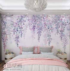 a bedroom decorated in pink and white with flowers on the wall