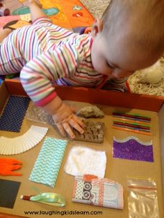 a baby playing with craft supplies on the floor