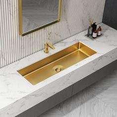 a bathroom with marble counter top and gold sink