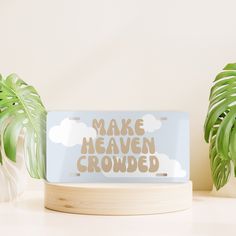 a sign that says make heaven crowded on it next to some plants and a potted plant