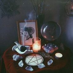 a table topped with candles and pictures next to a candle holder on top of a table