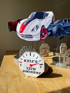 three toy cars sitting on top of a wooden table next to each other with different gauges