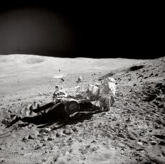 an astronaut on the surface of the moon with his rover vehicle in front of him