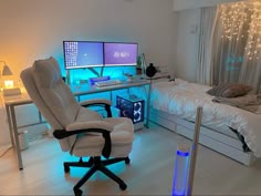 a white chair sitting in front of a computer desk with two monitors on top of it