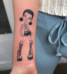 a woman's arm with a cartoon character tattooed on the left side of her arm