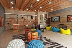 a living room filled with lots of furniture and hanging chairs next to a fire place