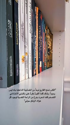 a row of books sitting on top of a white book shelf next to each other