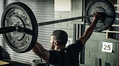 a man lifting a barbell in a gym