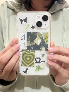 a woman holding up her phone case with stickers on it