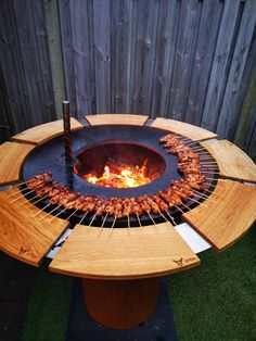 an outdoor grill with hot dogs on it