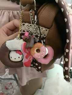 a person holding a purse with charms attached to it