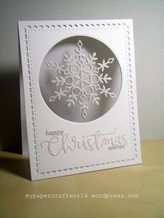 a white card with a snowflake on it and the words happy christmas written in cursive writing