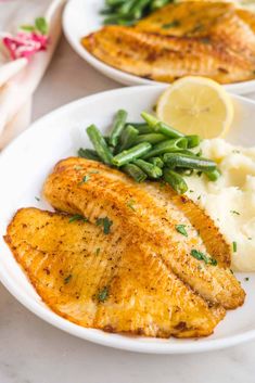 pan fried tila with green beans and mashed potatoes on a white platter