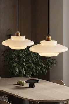 three lights hanging over a wooden table in a room