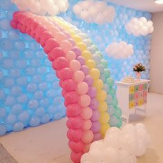 there is a rainbow balloon arch in the room