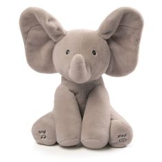 an elephant stuffed animal sitting on top of a white floor next to another stuffed animal