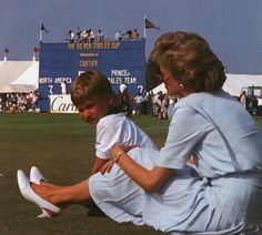 a woman and child sitting on the grass