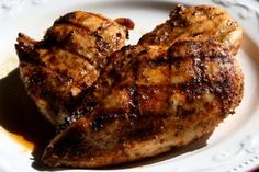 two pieces of meat sitting on top of a white plate