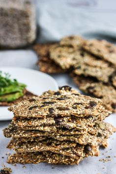 a stack of cookies sitting on top of a white plate next to broccoli