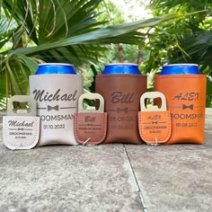 four different colored can coolers sitting on top of a cement floor next to palm trees