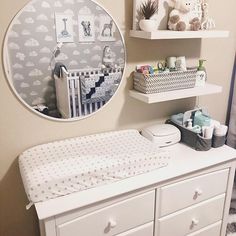 a baby's nursery room with white furniture and decor on the wall, including a crib