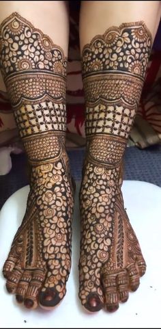 the legs and feet of a woman with henna tattoos