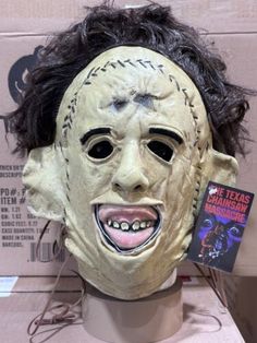 a creepy mask is on display in front of a cardboard box