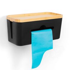 a black and blue tissue dispenser hanging on a wall with a wooden cutting board