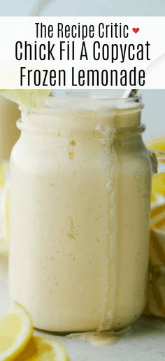 a glass jar filled with liquid next to sliced lemons