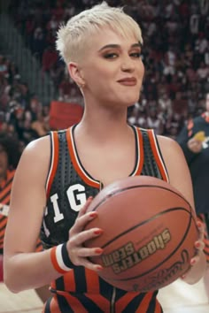 a woman holding a basketball in her right hand and looking at the camera with an excited look on her face